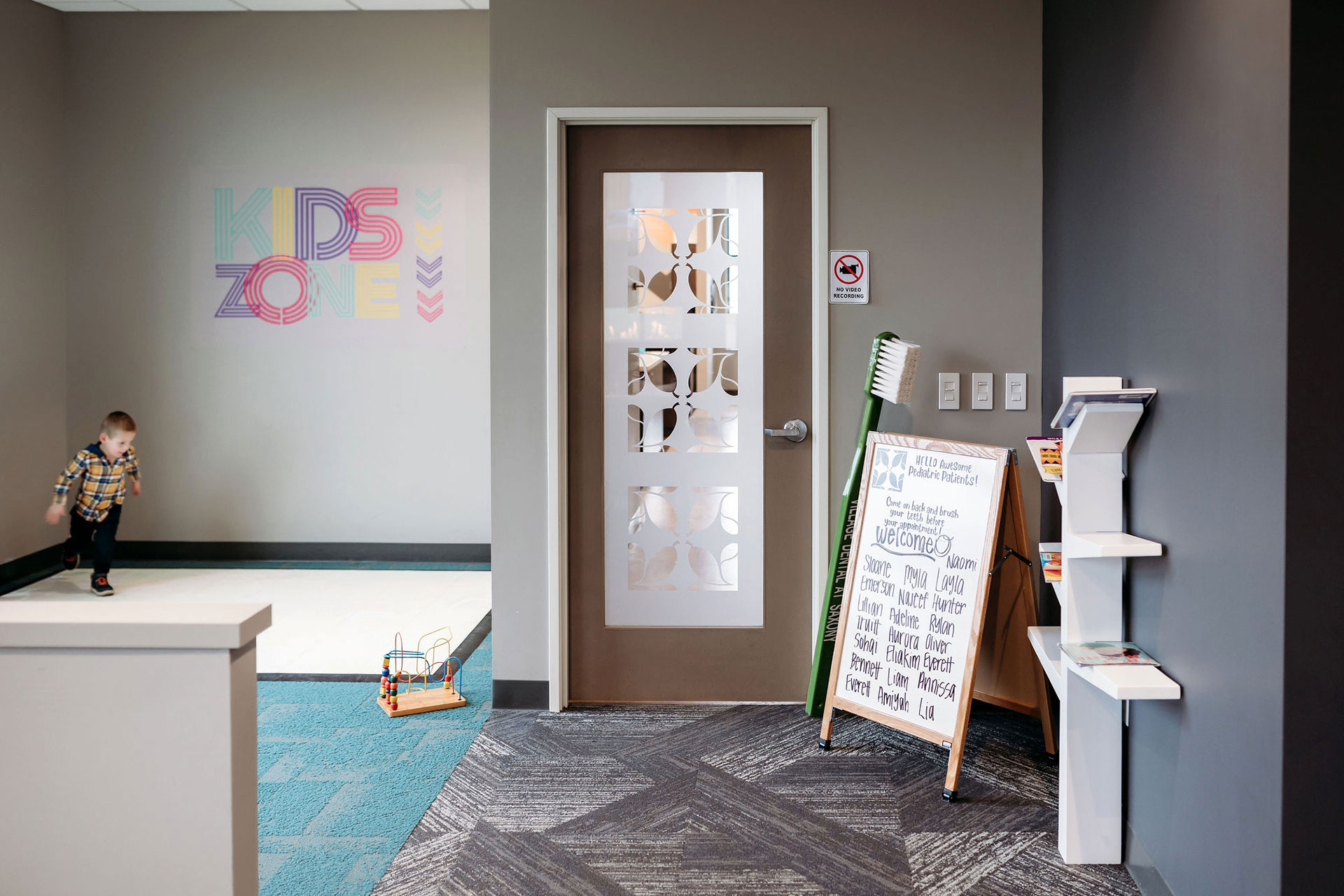 vds-office-1 Kids Zone play area at Village Dental with a welcome board and toys.