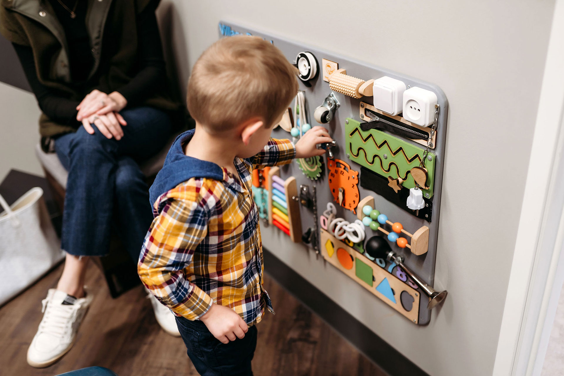 vds-office-6 Child exploring an activity wall in the Village Dental waiting area.